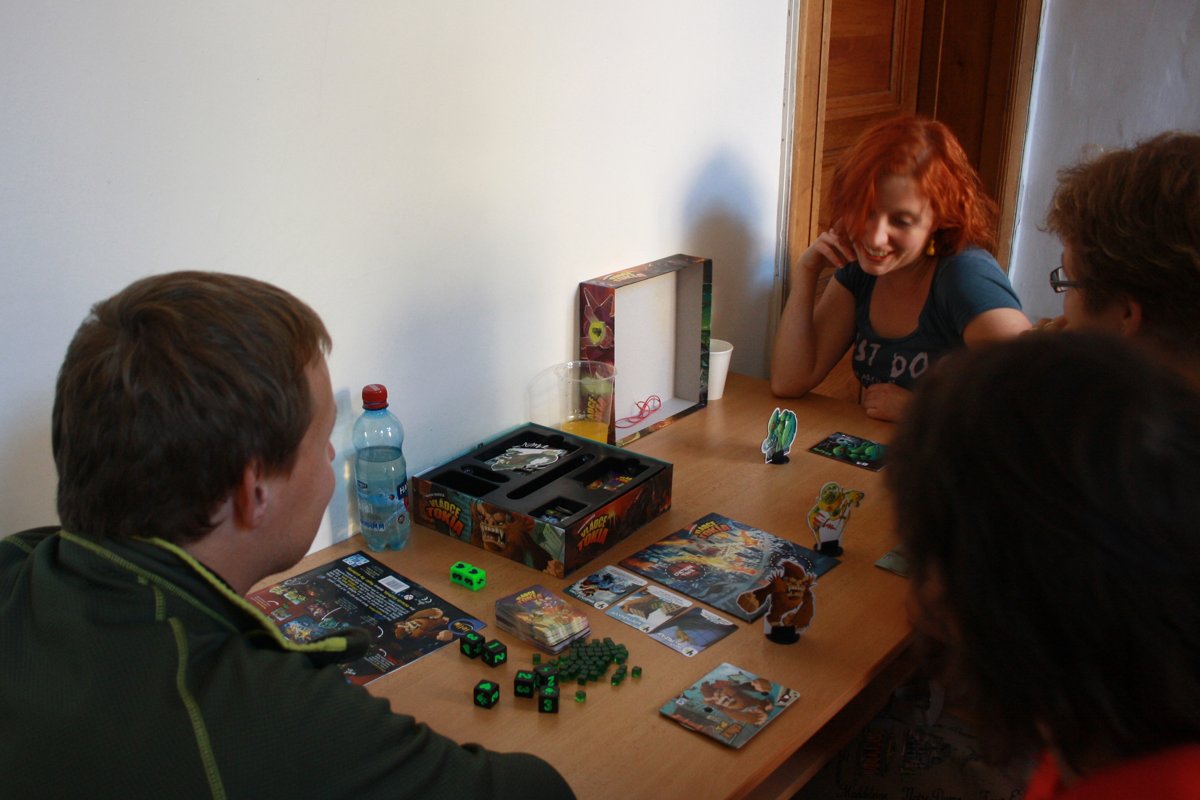 Friends playing King of Tokyo with monster standees and green dice