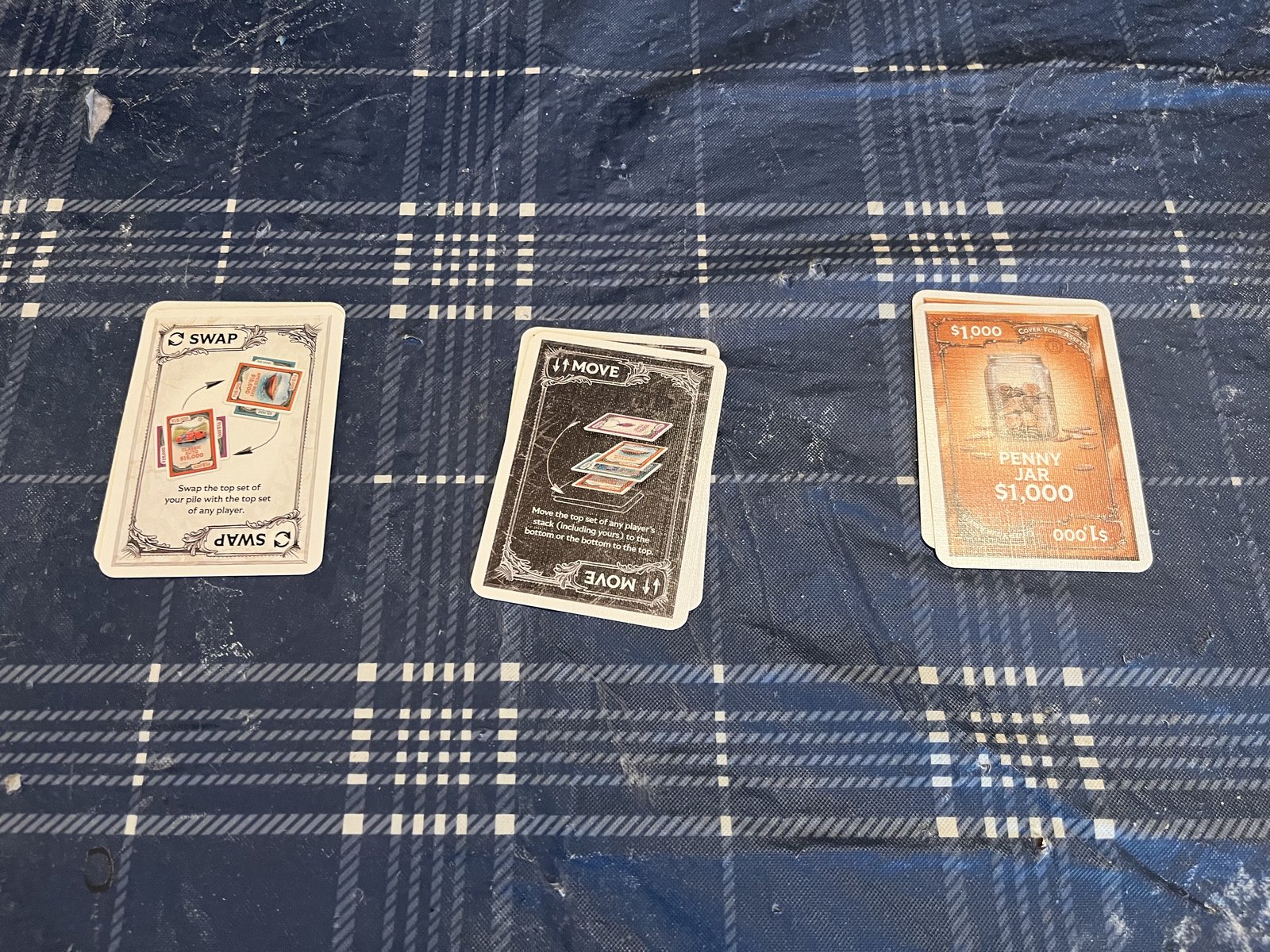 The Swap, Move, and Penny Jar cards from Cover Your Assets laid out on a table — the advanced cards most owners remove during setup and never play with