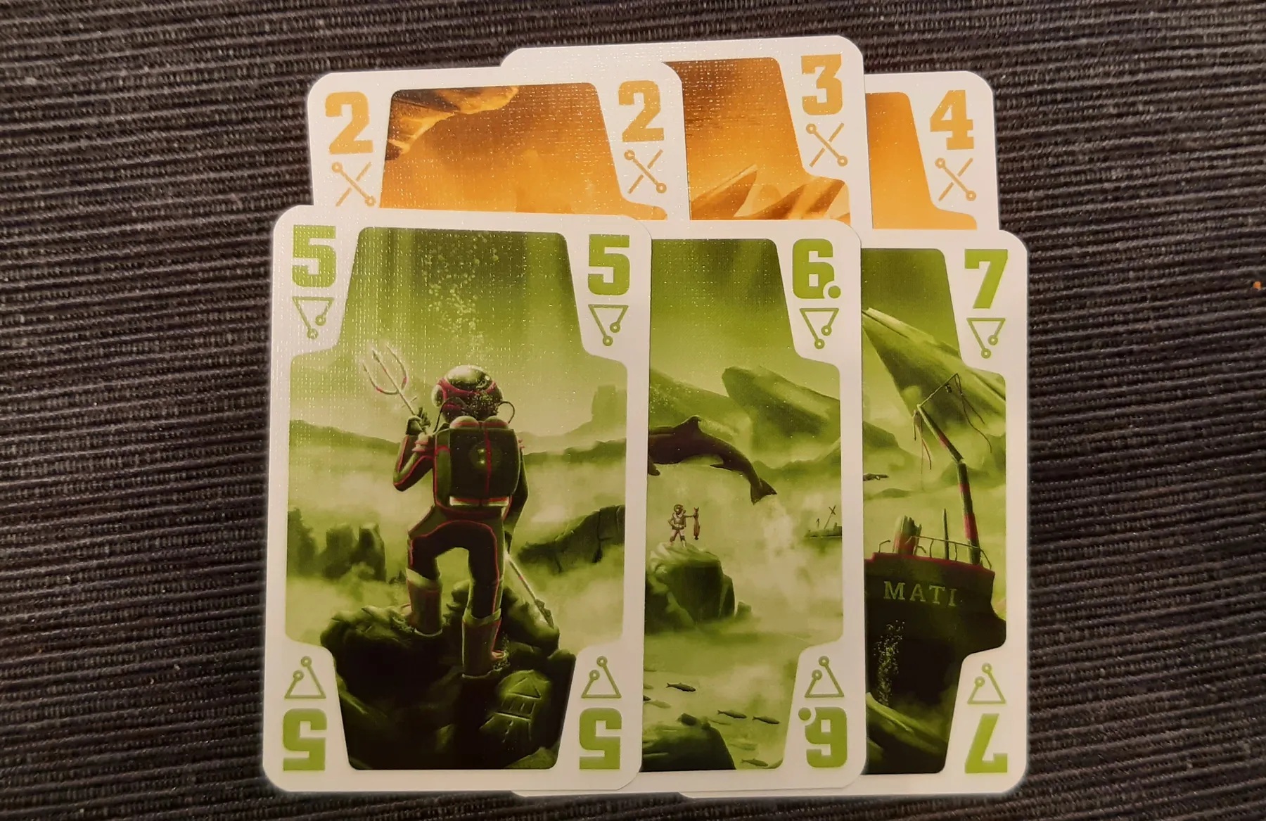 Two fans of numbered colour cards, orange and green
