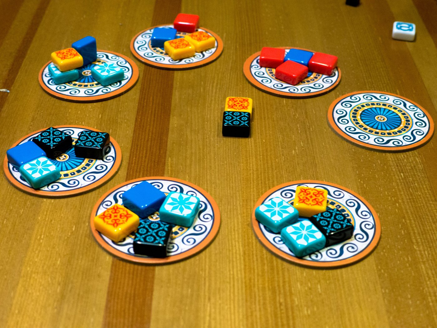 Azul factory displays loaded with four tiles each, with leftover tiles in the center of the table
