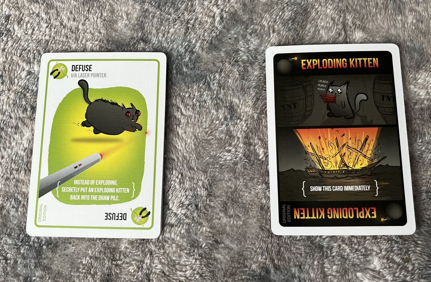A Defuse card next to an Exploding Kitten card from the Original Edition