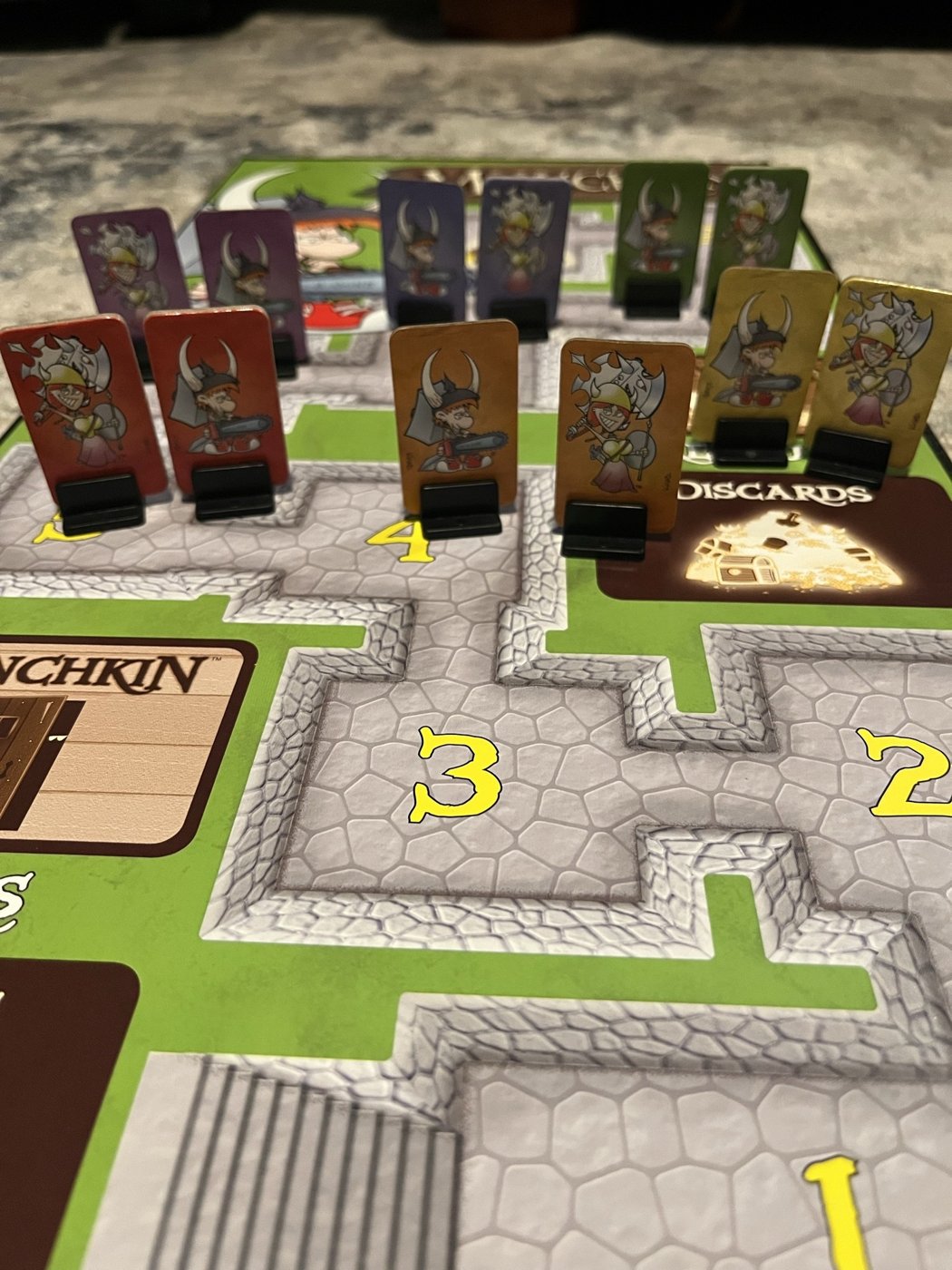Munchkin Deluxe standees on the level track of the gameboard