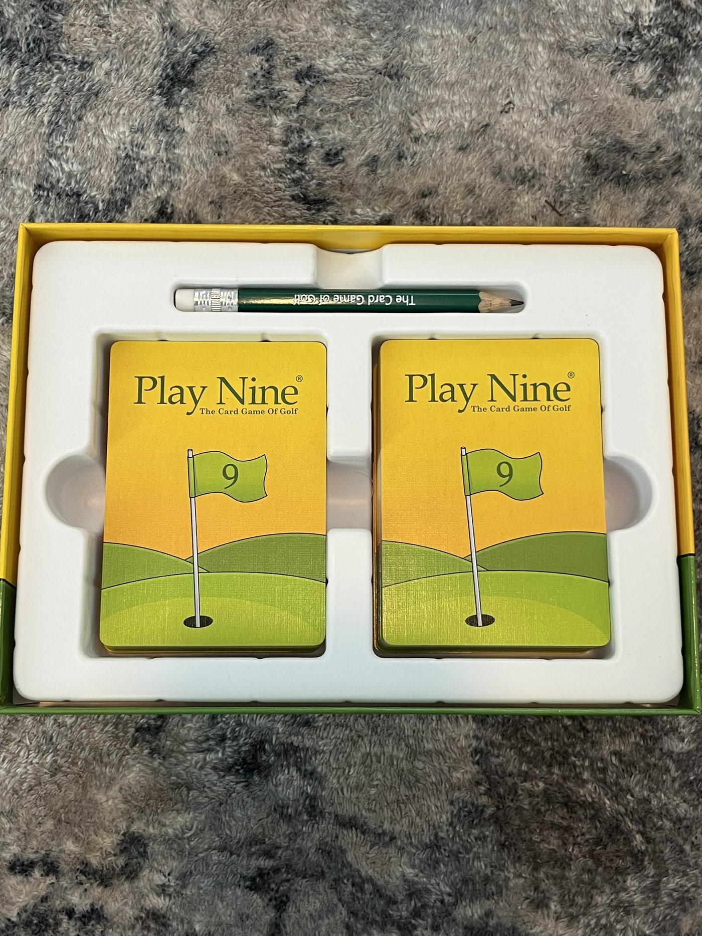 Inside the Play Nine box: two decks of cards and a pencil in the tray