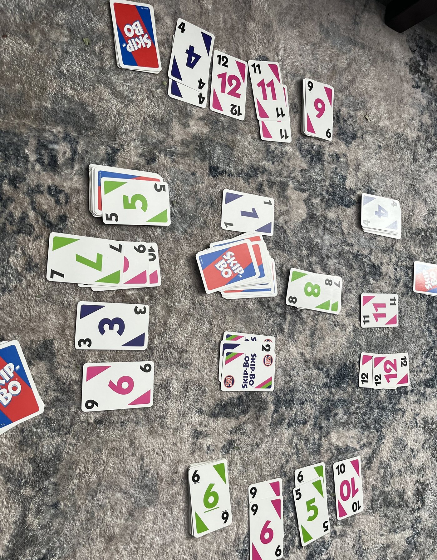 A Skip-Bo game laid out with building piles in the middle and stock and discard piles around them