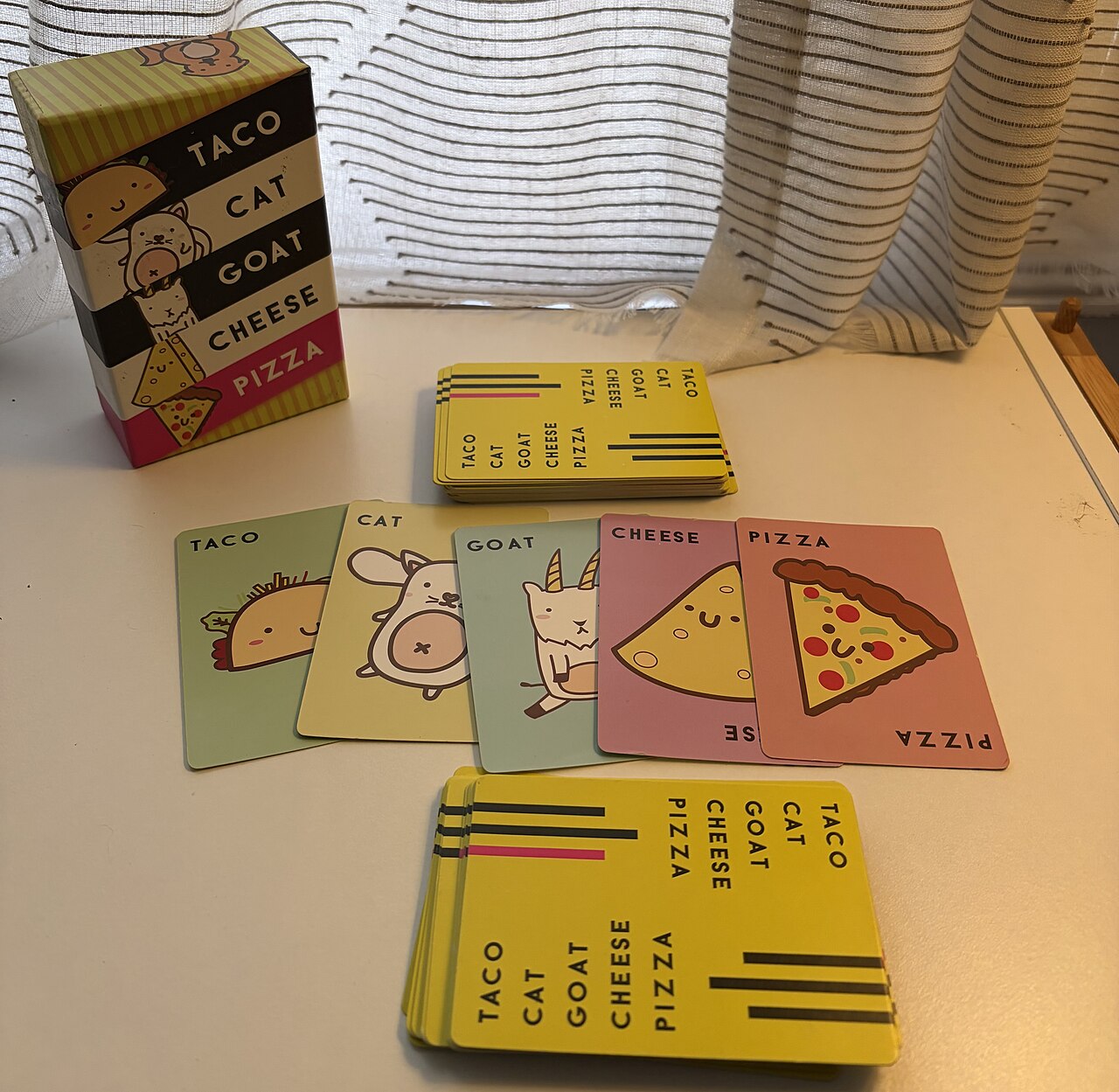 The Taco Cat Goat Cheese Pizza box with the taco, cat, goat, cheese and pizza cards laid out